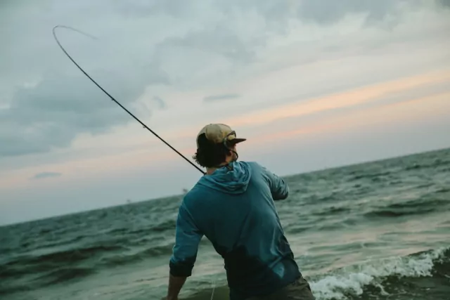 A man fishes in the ocean.
